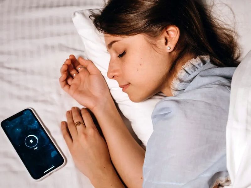 Woman sleeping with phone alarm