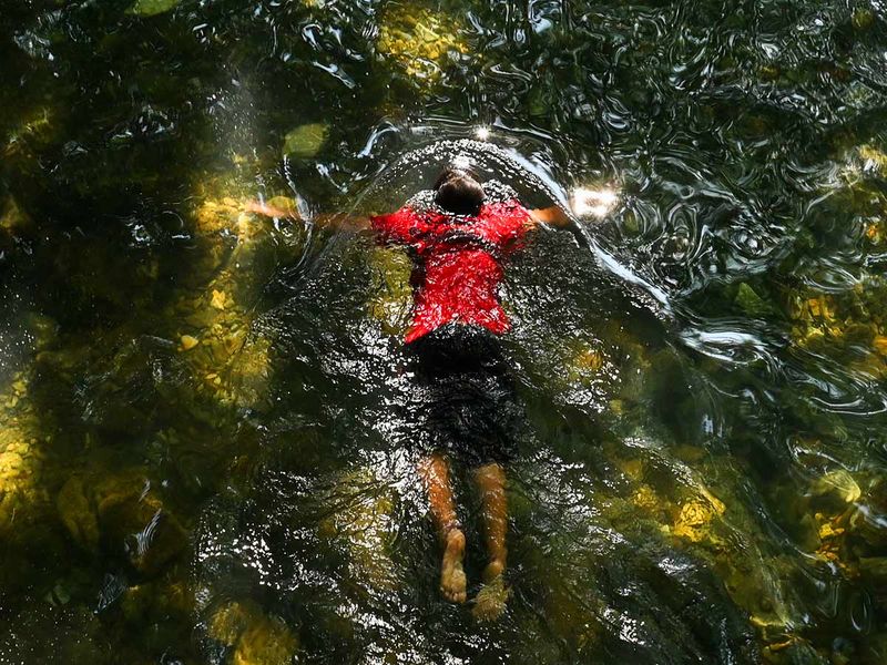 A child floats in a public pool of spring water in Japakeh, Indonesia's Aceh province on March 22, 2023, during the World Water Day.