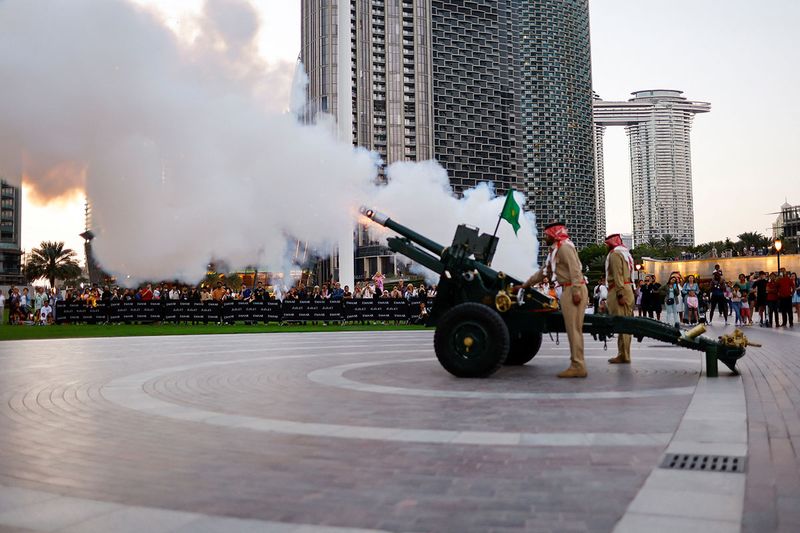 Dubai Police officers fire a cannon to mark the end of fasting day outside Dubai mall during the holy month of Ramadan, in Dubai, United Arab Emirates, March 29, 2023. 