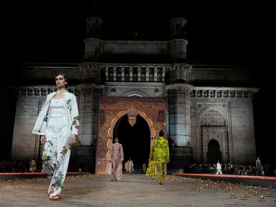 Models display creations for the Dior Pre-Fall 2023 collection at the Gateway of India monument in Mumbai 