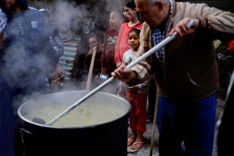 Palestinians gather to get soup offered for free during Ramadan, in Gaza City, March 26.