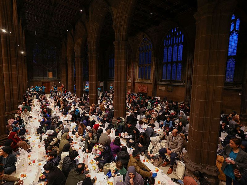People eat while breaking their fast during the Muslim holy fasting month of Ramadan, at Manchester Cathedral, in Manchester, Britain, March 29, 2023.