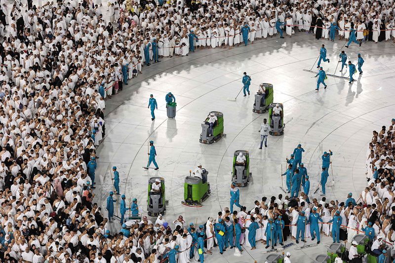 Cleaning staff sanitise the grounds outside the Kaaba, Islam's holiest shrine, as Muslim worshippers stand by to pray at the Grand Mosque in the holy city of Mecca on March 23, 2023 on the first day of the holy fasting month of Ramadan.