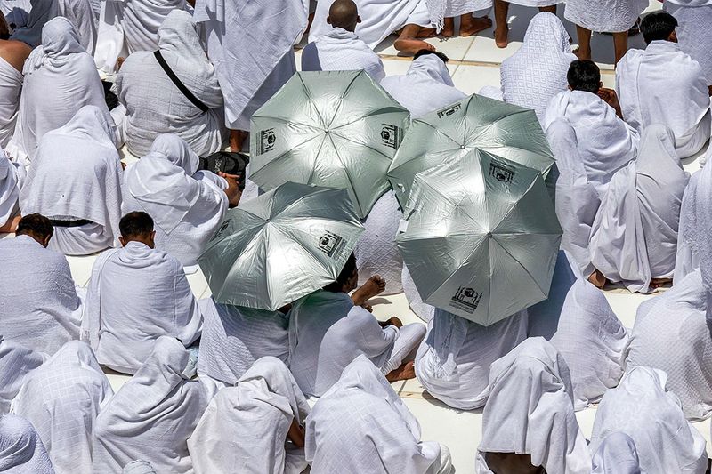 Muslim worshippers sit with umbrellas around the Kaaba  Islam's holiest shrine, at the Grand Mosque in the holy city of Mecca. 