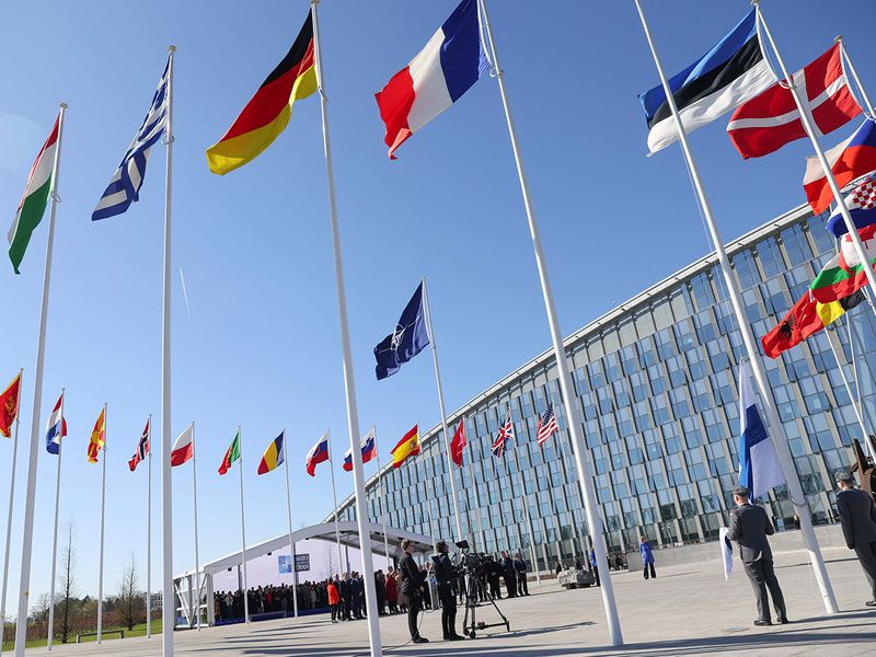 Officials attend a flag-raising ceremony after Finland's accession to NATO