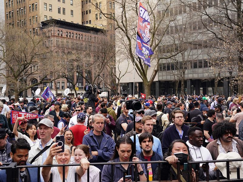 People gather in a park as former US president Donald Trump is arraigned in lower Manhattan on April 4, 2023 in New York. 