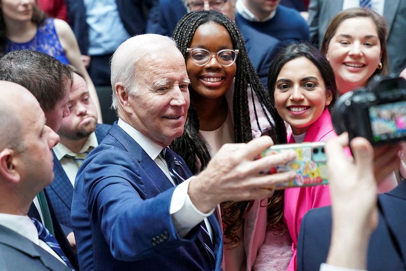 U.S. President Joe Biden takes a selfie with students follwing the 25th anniversary of the Belfast/Good Friday Agreement, at Ulster University, Belfast, Northern Ireland April 12, 2023