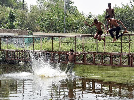 Children jump in Kondli canal to beat the scorching heat, in New Delhi on Saturday. 
