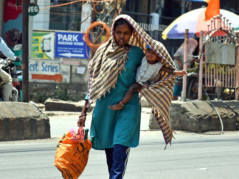  A woman covers her child to protect from the scorching heat amid a rise in temperature, in Ranchi on Tuesday.