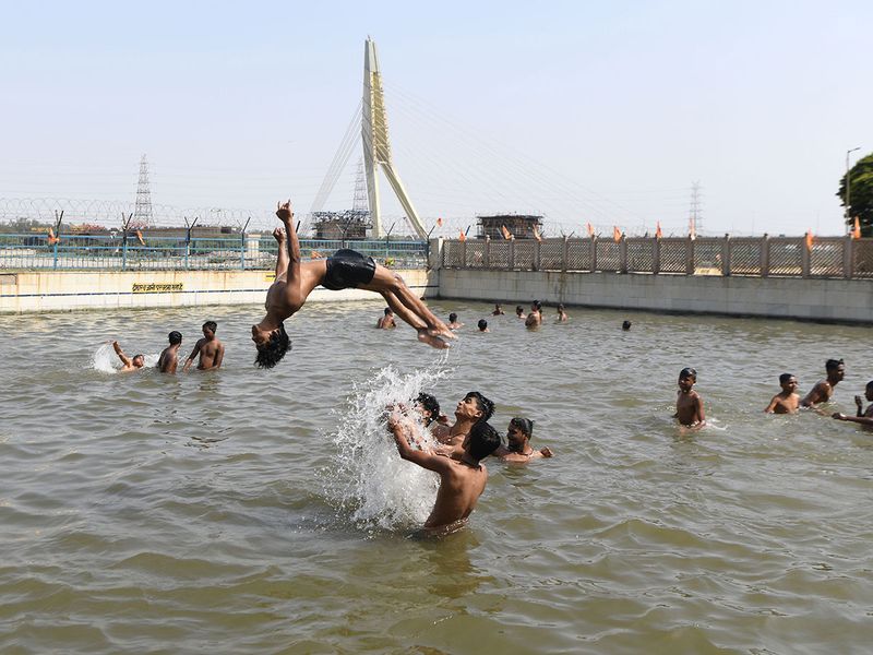 Children jump into swimming pool to relieve themselves from the scorching heat on a hot summer day, in New Delhi on Sunday.