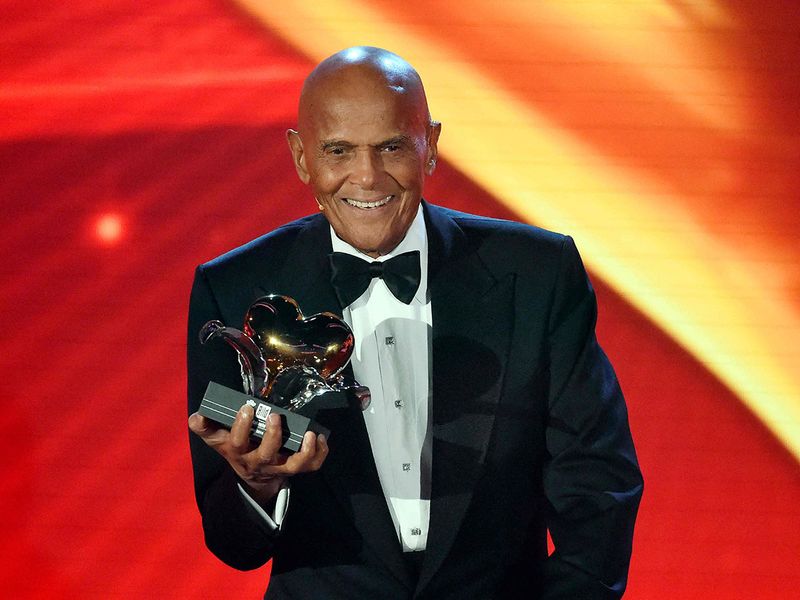  In this file photo taken on December 06, 2014, US singer and civil rights activist Harry Belafonte holds his Golden Heart award for his social commitment during the charity gala 