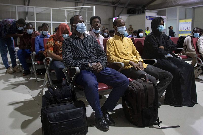 Kenyan and Somalian citizens wait to be processed by immigration officials after being evacuated aboard a Kenya Airforce aircraft to flee the deadly conflict in Sudan's capital, Khartoum, at the Jomo Kenyatta Airport in Nairobi, on April 24, 2023.