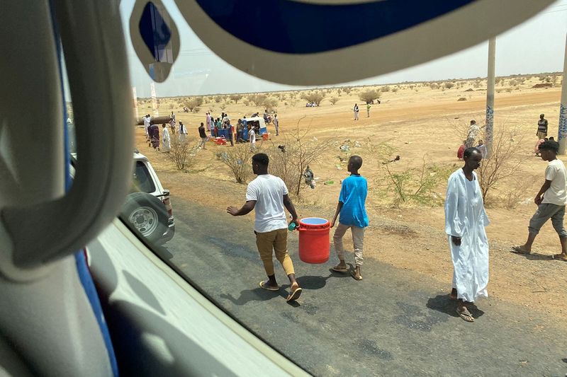 People carry kerkade (hibiscus) juice and cold water to distribute them to people amid evacuations from Khartoum to Port Sudan April 23, 2023 in this picture obtained from social media. 