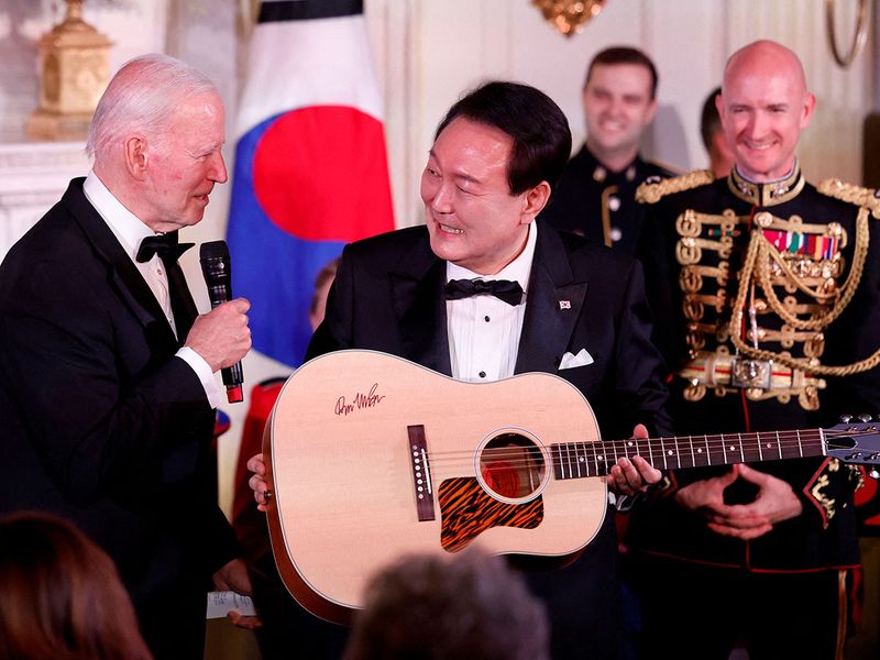 U.S. President Joe Biden presents a guitar signed by artist Don McLean to South Korea's President Yoon Suk Yeol at an official State Dinner, during Yoon Suk Yeol's visit, at the White House in Washington, U.S. April 26, 2023. 