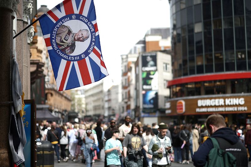 A King Charles souvenir flag hangs outside a shop ahead of the Coronation of King Charles and Camilla, Queen Consort in London, Britain, April 30, 2023. 