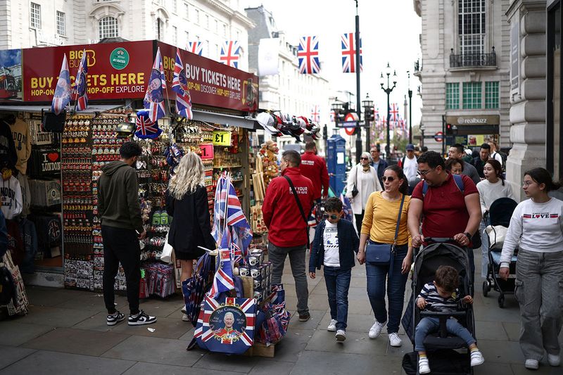People walk past a souvenir kiosk selling Coronation themed items at Piccadilly Circus, ahead of the Coronation.