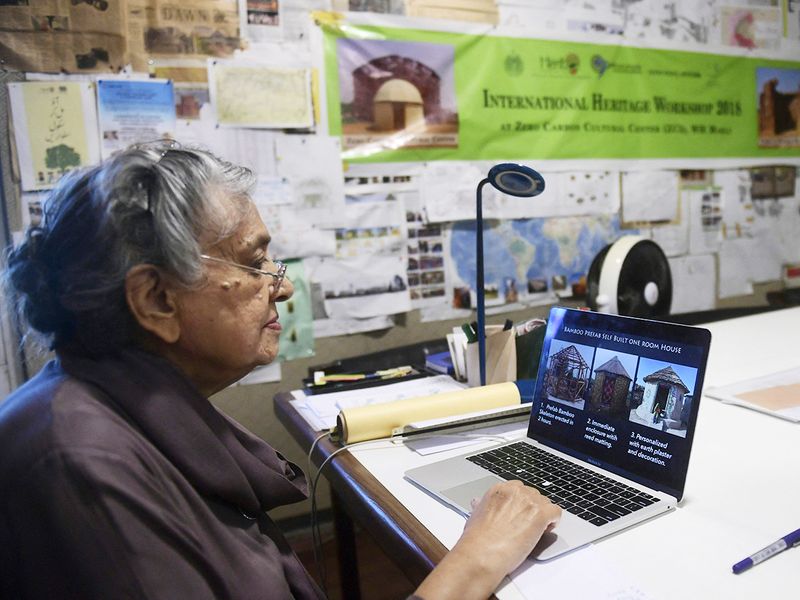 Architect Yasmeen Lari shows pictures of huts on a laptop at her office in Karachi.  