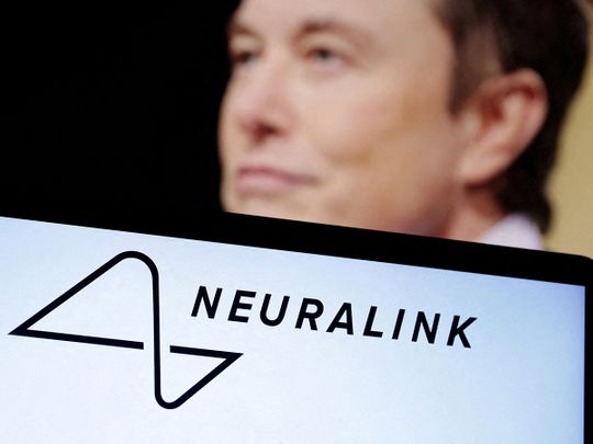 Neuralink logo and Elon Musk photo are seen in this illustration. 
