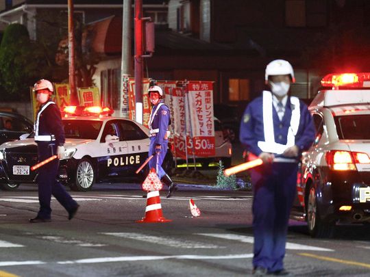 Police officers stand guard on a street near a building where the suspect is holed up in Nakano, central Japan. 