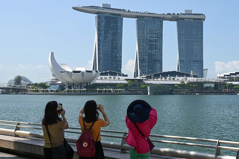 2023 年 5 月 25 日，人们在新加坡滨海湾金沙酒店度假村拍照。 