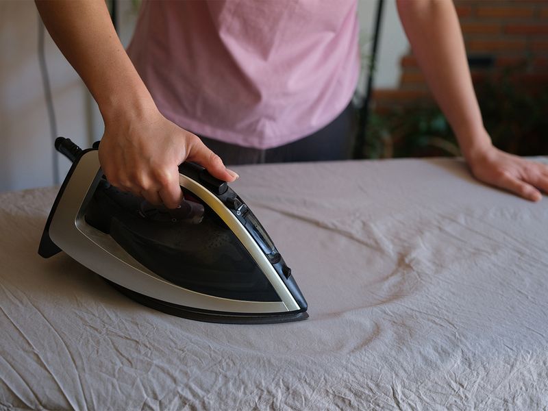 Person ironing sheets