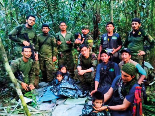 In this photo released by Colombia's Armed Forces Press Office, soldiers and Indigenous men pose for a photo with the four Indigenous children who were missing after a deadly plane crash, in the Solano jungle, Caqueta state, Colombia, Friday, June 9, 2023. Colombian President Gustavo Petro said Friday that authorities found alive the four children who survived a small plane crash 40 days ago and had been the subject of an intense search in the Amazon jungle.