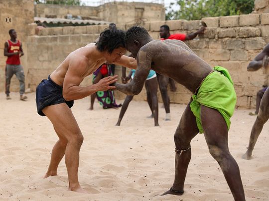 Shogo Uozumi (left) wrestles with Baye Ibra at the Samba Dia stable in the Diakhao neighbourhood, in Thies, Senegal. 
