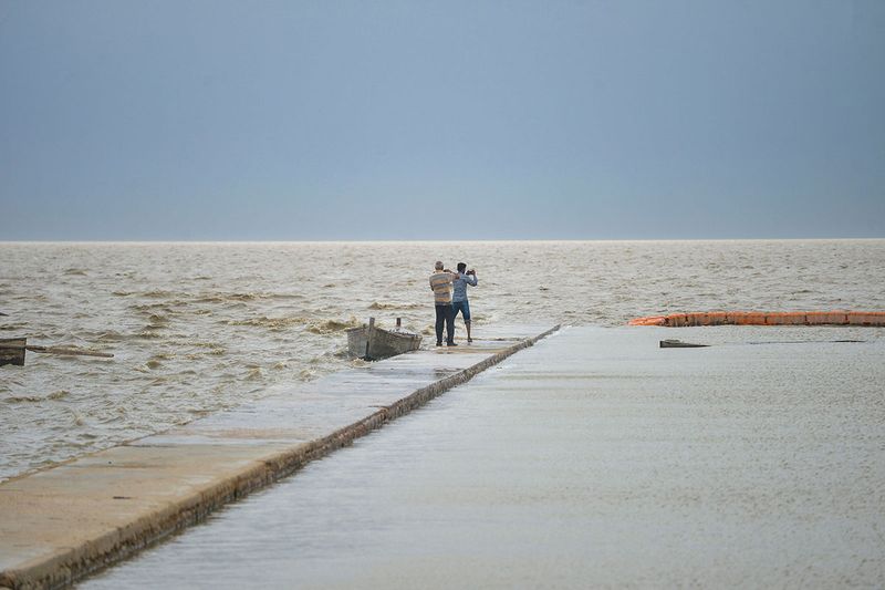 Above: Villagers stand along the Arabian Sea's coast, at the Zero Point in Badin district, Sindh province.