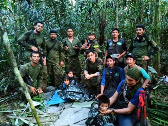 Soldiers and Indigenous men pose for a photo with the four children who were missing after surviving a deadly plane crash, in the Solano jungle, Caqueta state, Colombia, on June 9, 2023. 