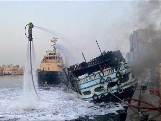 Firefighters at work to put out a fire that erupted in a dhow in Dubai early on Monday.,
