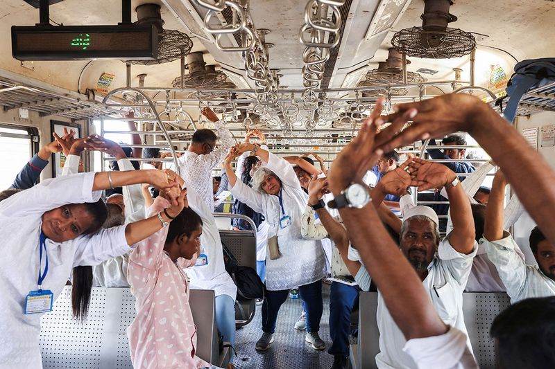 People perform yoga in a local train, during International Yoga Day in Mumbai, India, June 21, 2023.