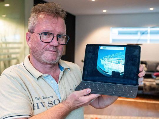 Arthur Loibl, one of the submersible company Oceangate's first customers, holds up a photo of the Titanic, in Straubing, Germany, Wednesday June 21, 2023.