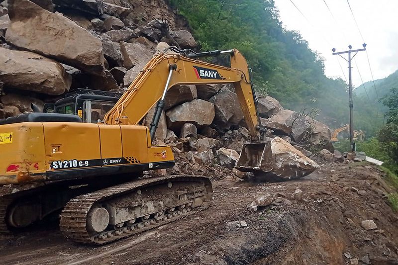 Debris being cleared from the Chandigarh-Manali highway after it got blocked following the landslides triggered by rainfall, in Mandi on Monday. 