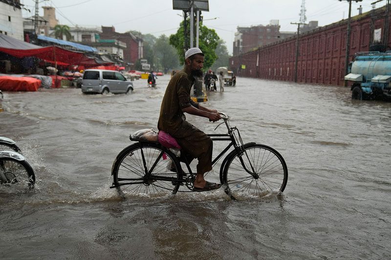 A cyclist rides through a flooded in Lahore.  Lahore, which is Pakistan’s cultural capital, received a record 272 millimeters (10.7 inches) of rain in nine hours. 