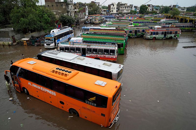 Buses are parked in a flooded terminal caused by heavy monsoon rainfall in Lahore, Pakistan, Wednesday, July 5, 2023. Officials say heavy monsoon rains have lashed across Pakistan, killing a number of people. 