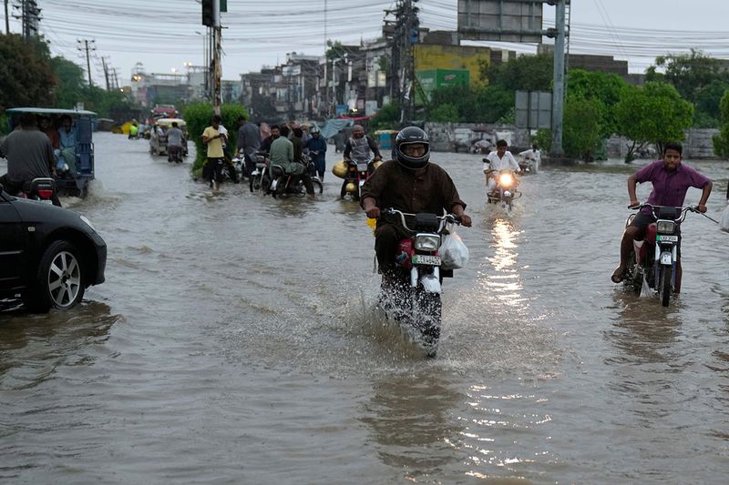 Motorcyclists drive through a flooded road caused by heavy monsoon rainfall in Lahore, Pakistan, Wednesday, July 5, 2023. Officials say heavy monsoon rains have lashed across Pakistan, killing a number of people