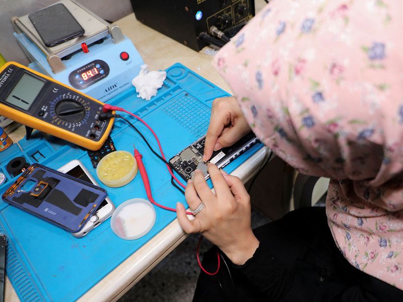 Walaa Hammad repairs mobile phones at her home in Gaza City. 