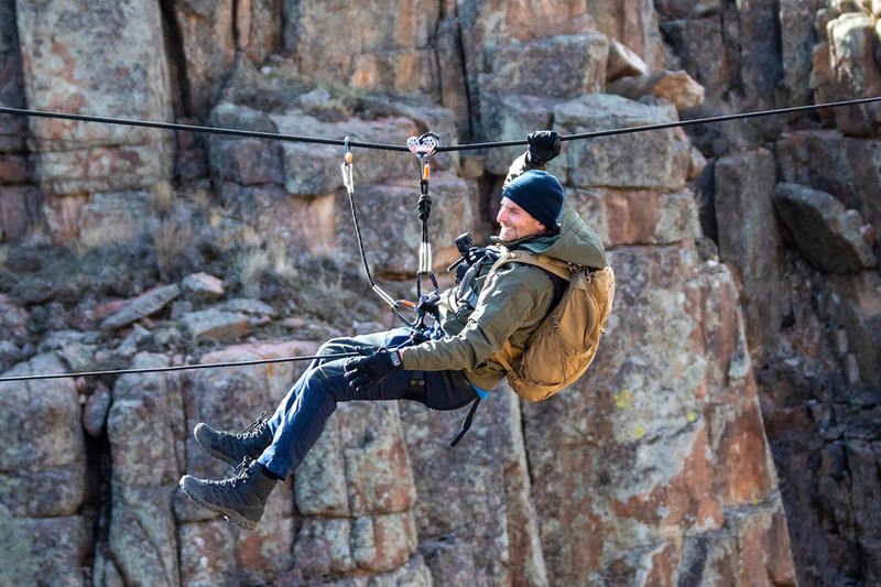 This image released by Nat Geo shows Bradley Cooper traversing across the canyon during his journey through the Pathfinder Canyon area in Wyoming, in a scene from “Running Wild with Bear Grylls: The Challenge,