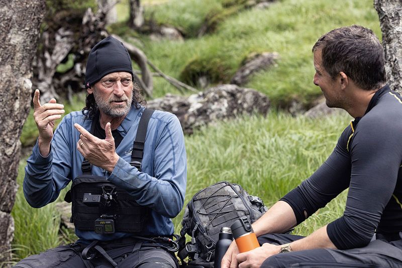 This image released by Nat Geo shows Troy Kotsur, left, signing to Bear Grylls in the Scottish Highlands, in a scene from “Running Wild with Bear Grylls: The Challenge,