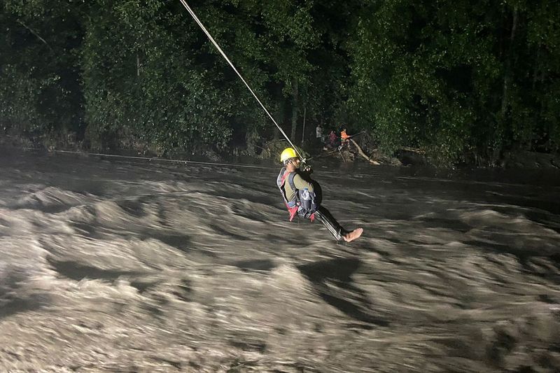 A civilian wearing safety-harness is helped to cross Beas river during an evacuation drive by the members of National Disaster Response Force (NDRF) following heavy rains at Nagwain village in the northern state of Himachal Pradesh, India, July 9, 2023. 