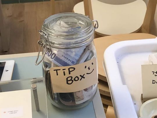 A Twitter post that shows a photo of a tip jar in a South Korean cafe has started an online debate.