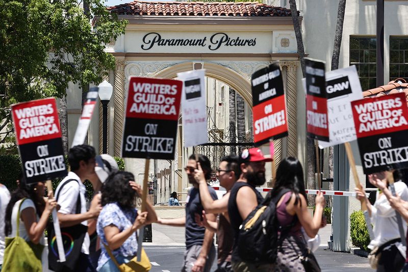 Striking WGA (Writers Guild of America) workers picket outside Paramount Studios on July 12, 2023 in Los Angeles, California. Members of SAG-AFTRA, which represents actors and other media professionals, may go on strike by 11:59 p.m. today which could shut down Hollywood productions completely with the writers in the third month of their strike against Hollywood studios.   