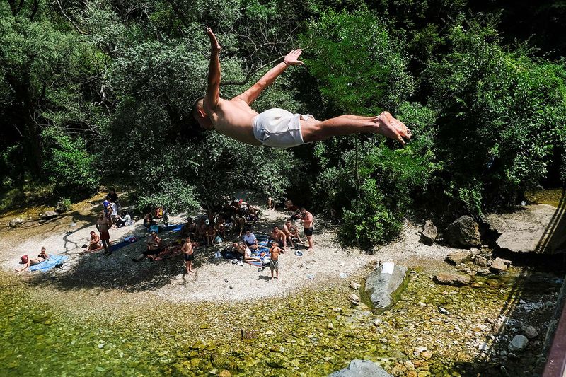 A boy jumps to cool off in the river Treska near Skopje on July 13, 2023, as temperatures reach about 40 degrees Celsius. A heatwave with temperatures of 40 degrees Celsius hit North Macedonia and the region. 