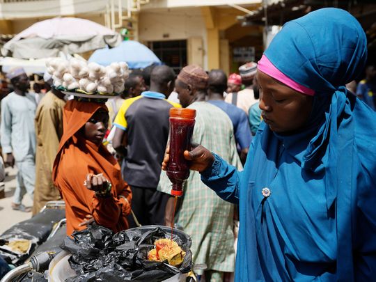A woman sells locally made food at a market in Kano, Nigeria. 