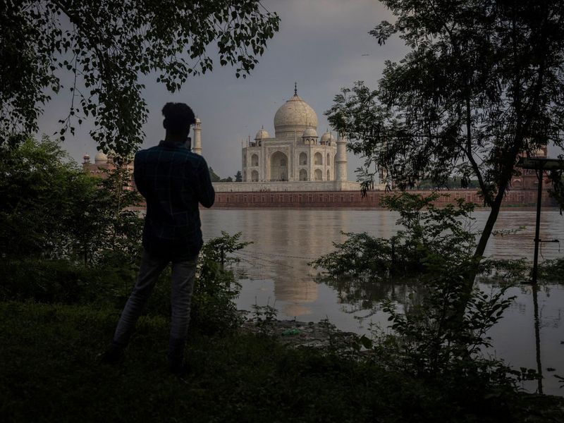 A man takes picture of historic Taj Mahal as the Yamuna river overflows following heavy rains, in Agra, India July 18, 2023