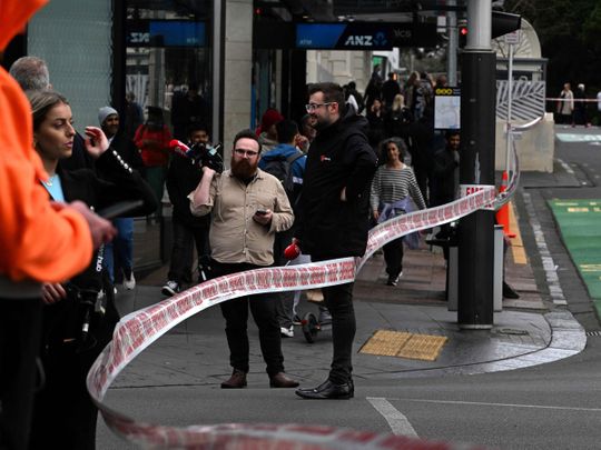 Media gather near the site of a shooting in central Auckland on July 20, 2023