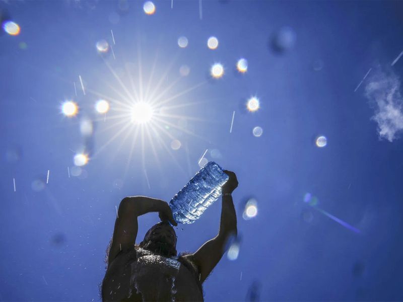 A man pours cold water onto his head to cool off on a sweltering hot day in the Mediterranean Sea in Beirut, Lebanon.