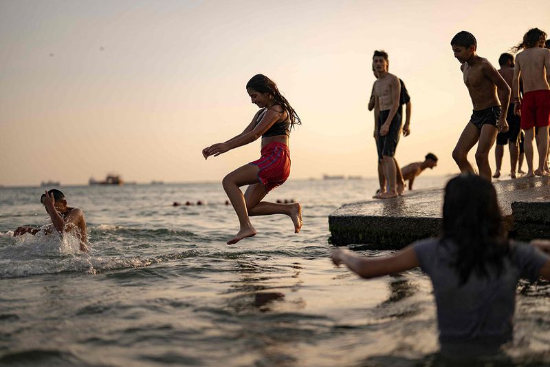 A girl jumps into the sea at Menekse beach in Istanbul.