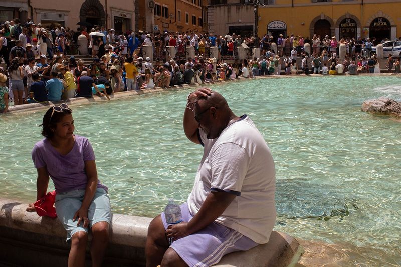 Tourists use water to keep cool at the Trevi Fountain during a heat wave in Rome on July 17. 