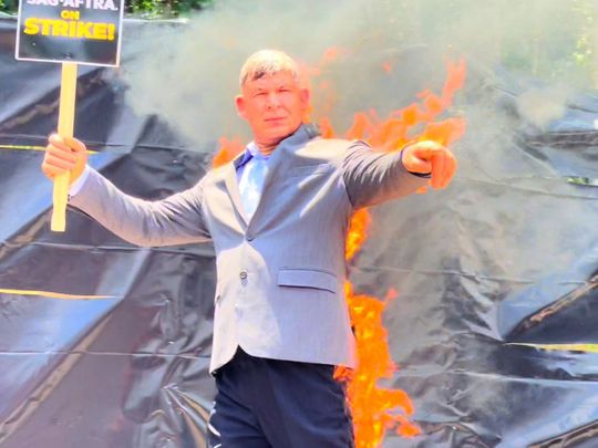 Mike Massa, who has been a stunt coordinator for more than 30 years, performs a fire stunt Monday at a SAG-AFTRA strike in Georgia.